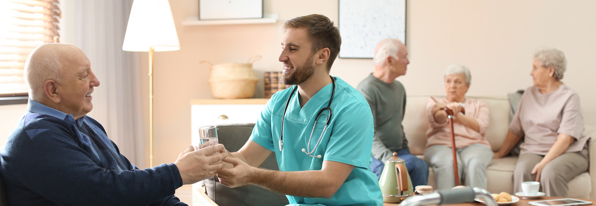 KombinationsleistungCare worker giving water to elderly man in geriatric hospice. Banner design Pflegekraft gibt einem älteren Mann in einem Seniorenheim Wasser.